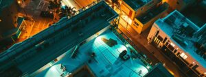 a dynamic urban scene in pompano beach, showcasing a professional roofing team swiftly repairing a leaky roof on a modern building under bright artificial lights, emphasizing the urgency and importance of immediate roofing assistance.